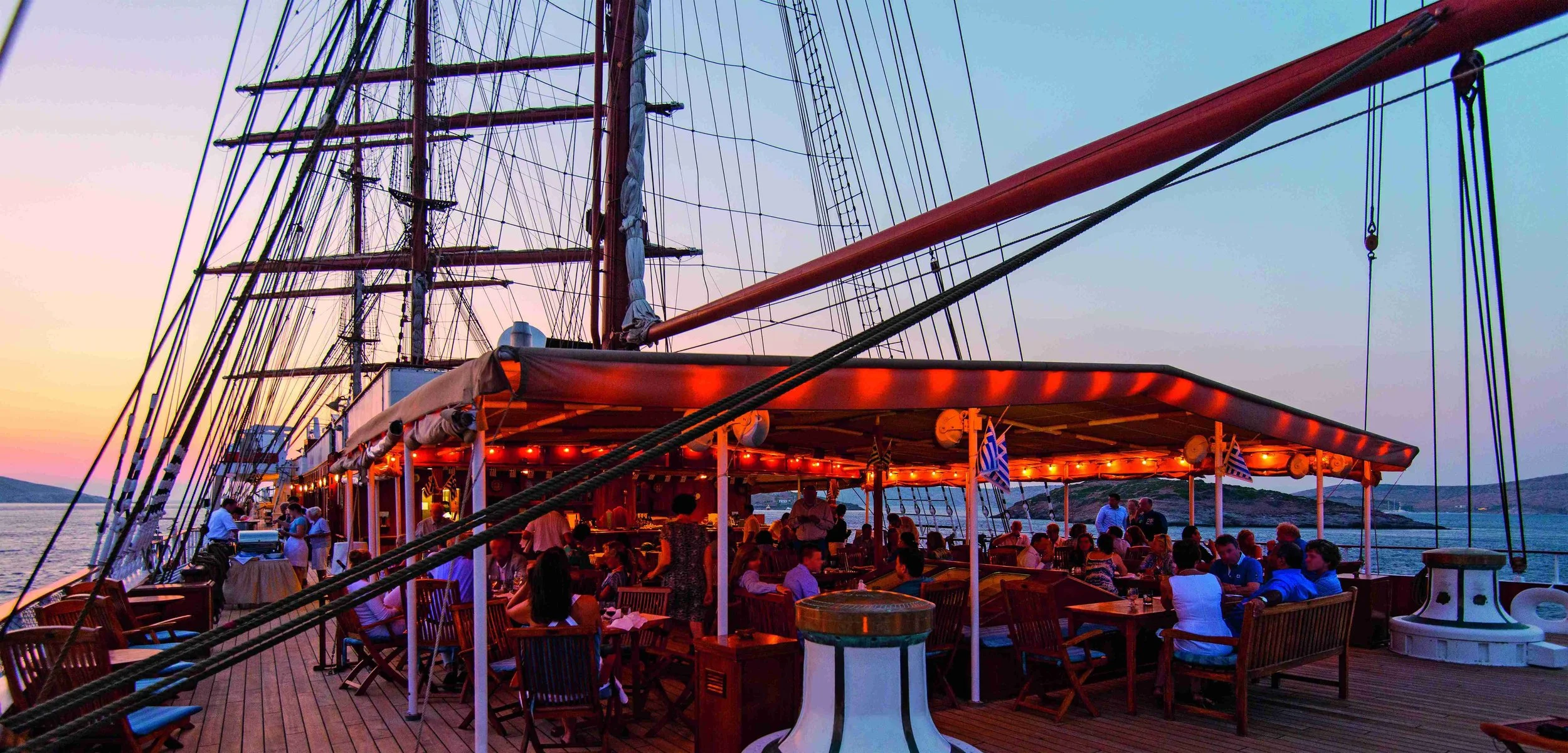 Sea Cloud II teak deck with guests relaxing under sail