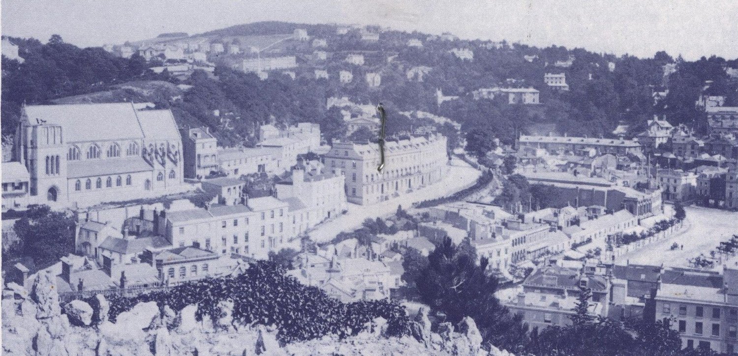 Panoramic Victorian photograph looking down over Torquay with the part-built St John's Church on the left and the terraces of the town below