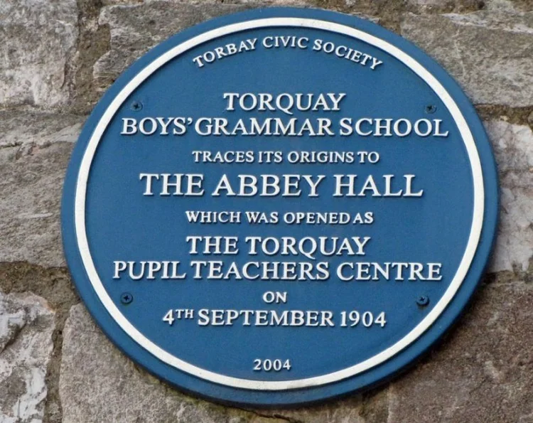 Blue plaque reading Torbay Civic Society, Torquay Boys' Grammar School traces its origins to The Abbey Hall, which was opened as the Torquay Pupil Teachers Centre on 4th September 1904