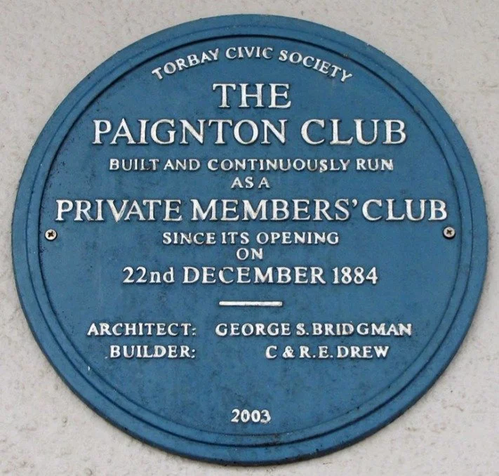 Blue plaque reading Torbay Civic Society, the Paignton Club, built and continuously run as a private members' club since its opening on 22nd December 1884, architect George S. Bridgman, builder C and R.E. Drew