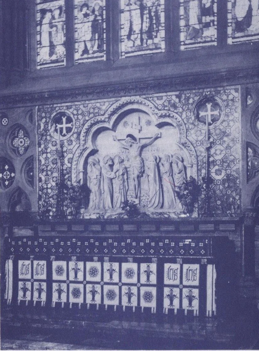 The chancel of St John's, Torquay, showing the carved stone reredos with the Crucifixion scene above the decorated altar