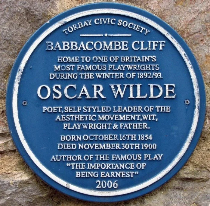 Blue plaque reading Torbay Civic Society, Babbacombe Cliff, home to one of Britain's most famous playwrights during the winter of 1892 to 93, Oscar Wilde, poet, self styled leader of the aesthetic movement, wit, playwright and father, born October 16th 1854 died November 30th 1900, author of the famous play The Importance of Being Ernest, 2006
