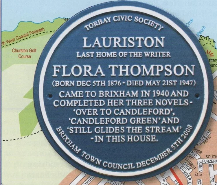 Blue plaque reading Torbay Civic Society, Lauriston, last home of the writer Flora Thompson, born December 5th 1876, died May 21st 1947, came to Brixham in 1940 and completed her three novels, Over to Candleford, Candleford Green and Still Glides the Stream, in this house, Brixham Town Council December 5th 2008