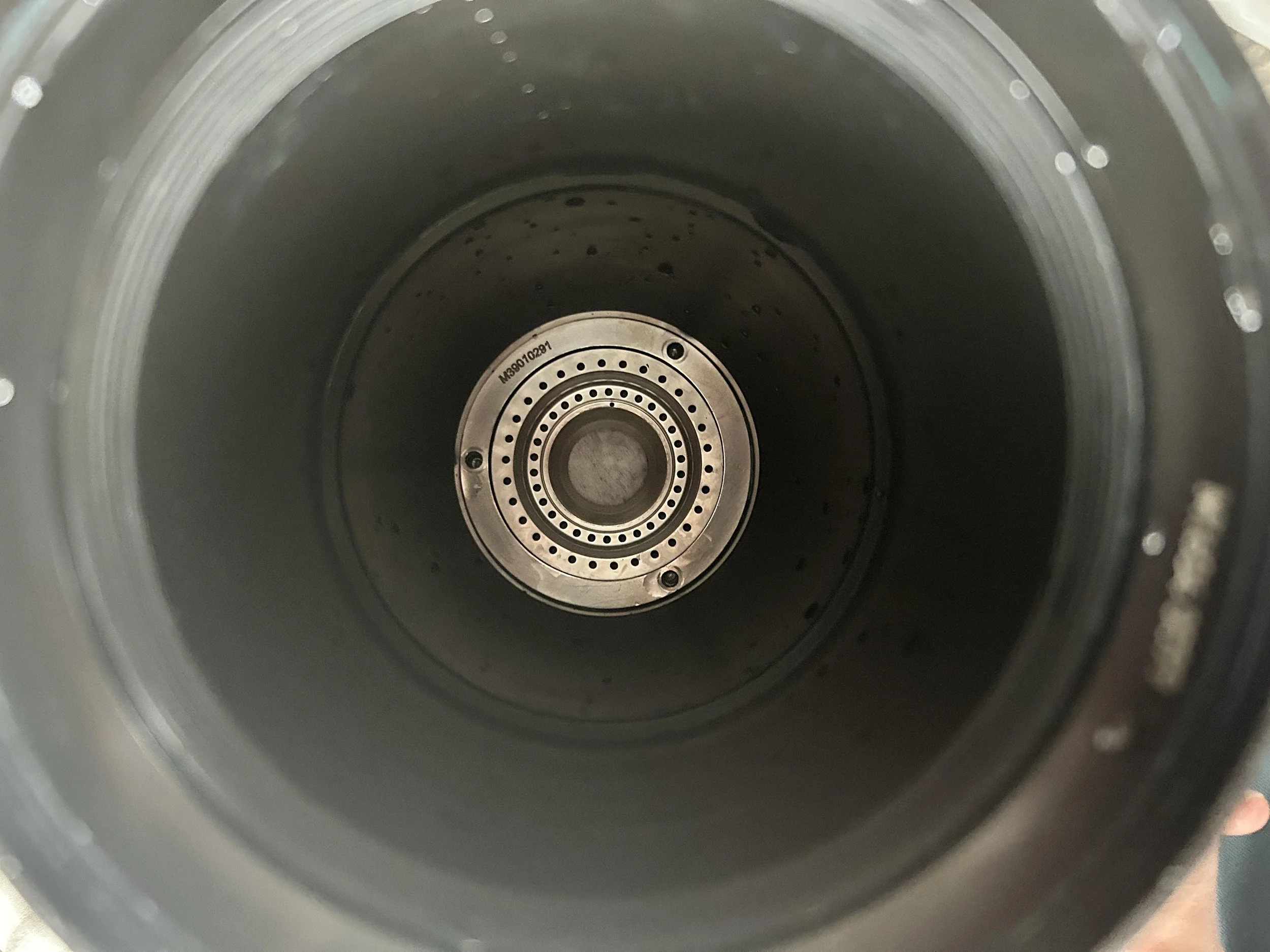 Close-up of rotary atomizer components inspected during preventive maintenance