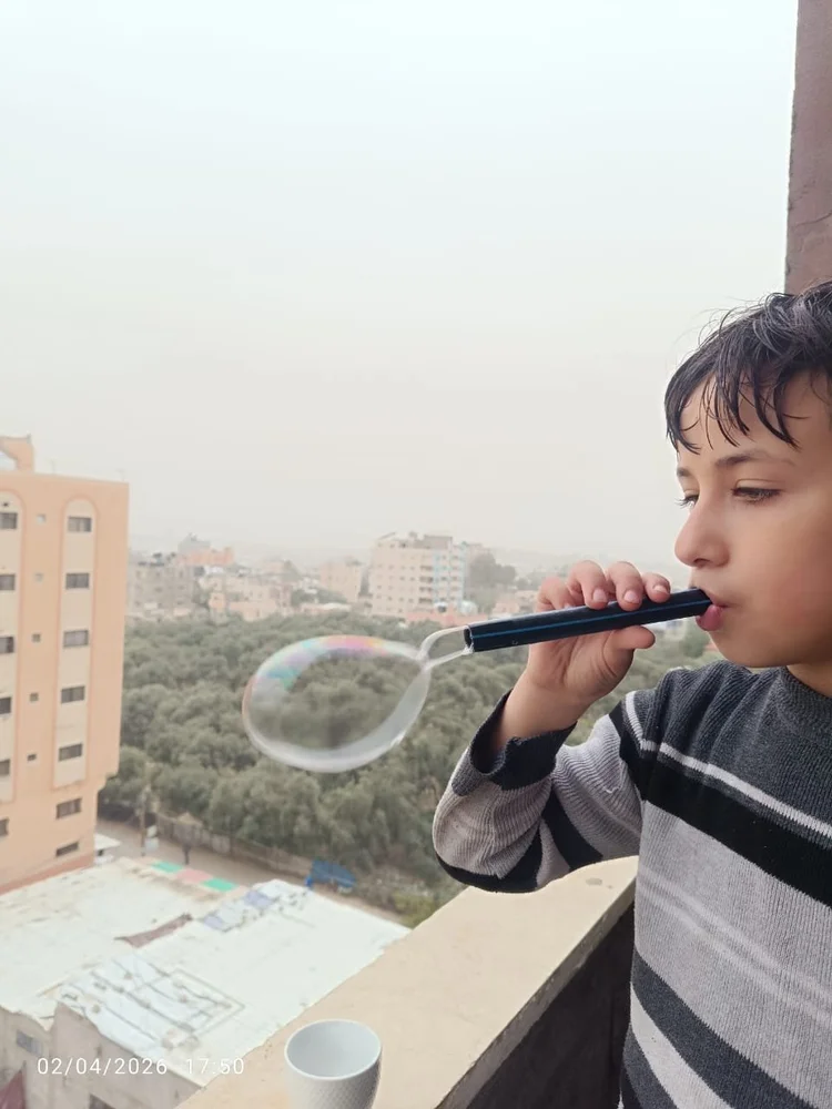 A child concentrating on blowing a bubble