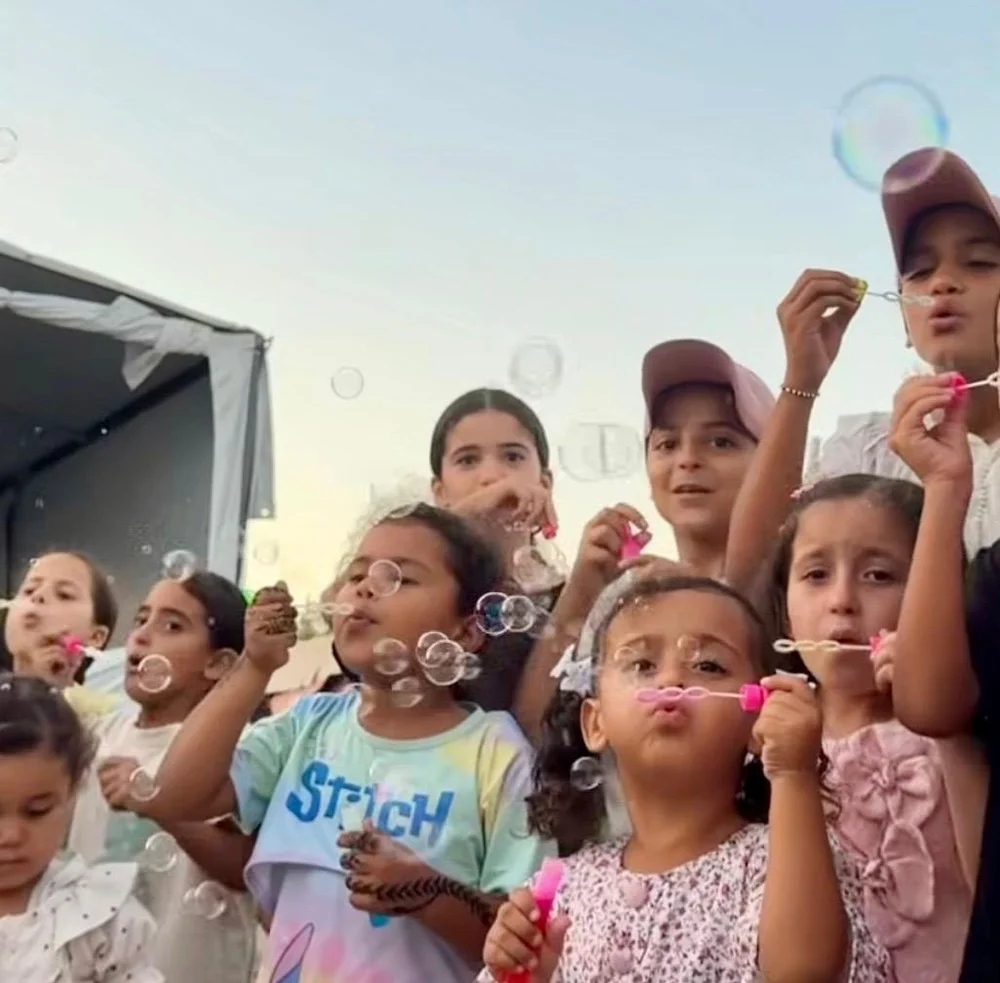 Children watching and making bubbles together outdoors