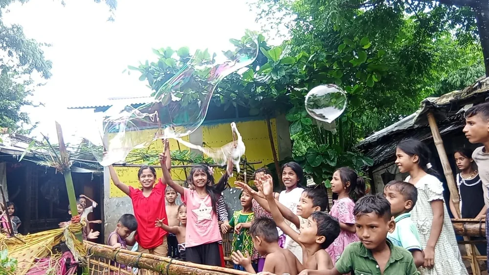 Children sharing bubble play outdoors