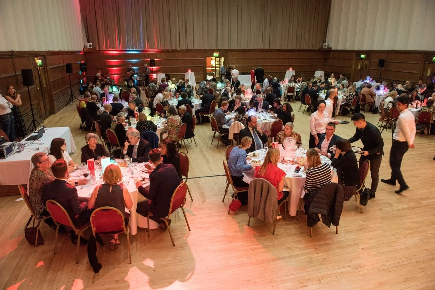 Guests at round tables during an awards dinner in a panelled hall
