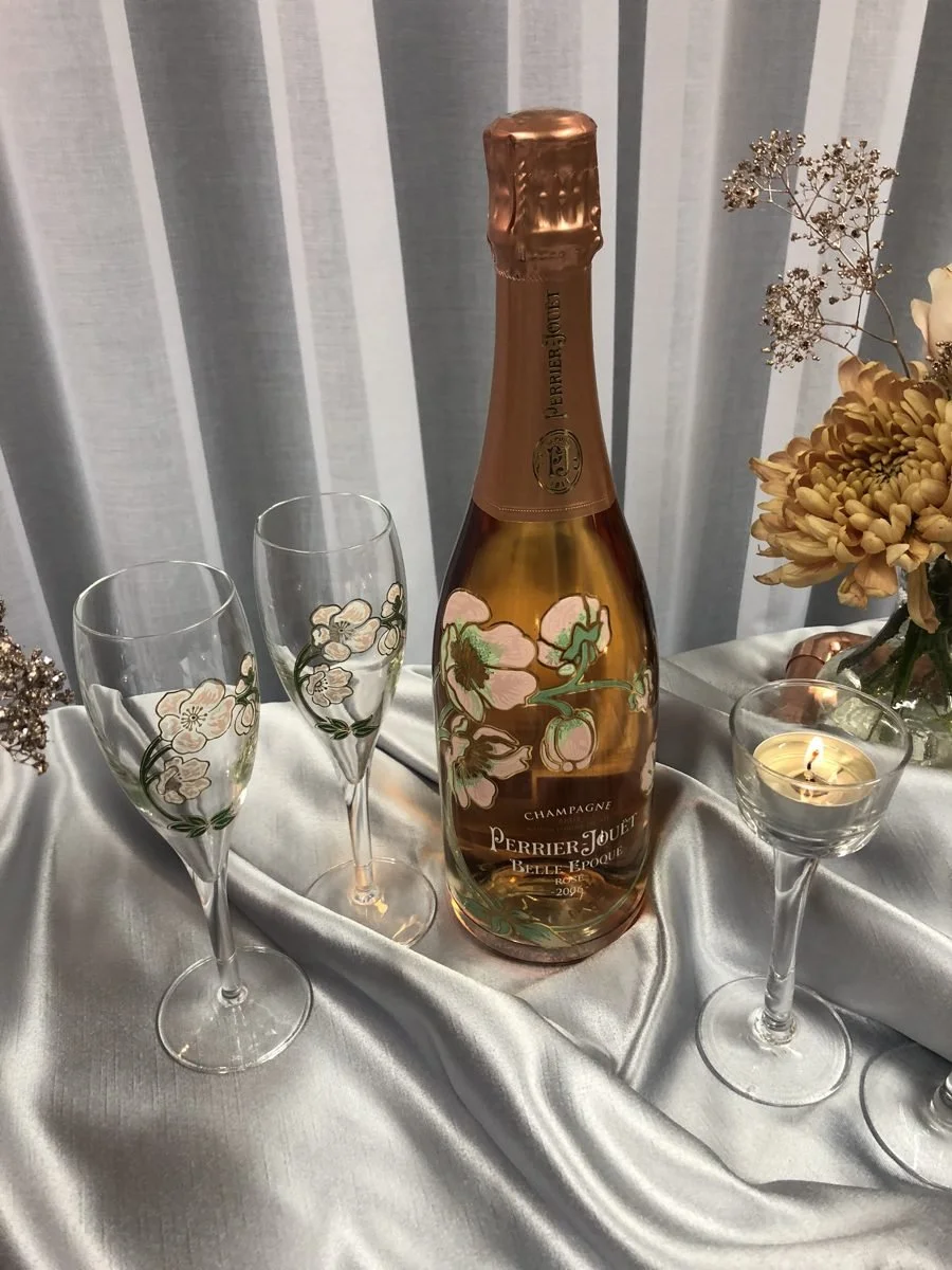 Champagne, candles and flowers on a silver satin table