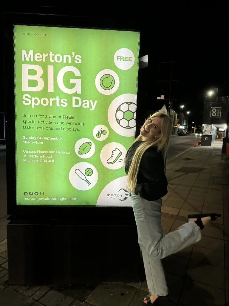 Layla beside a street poster for Merton's Big Sports Day