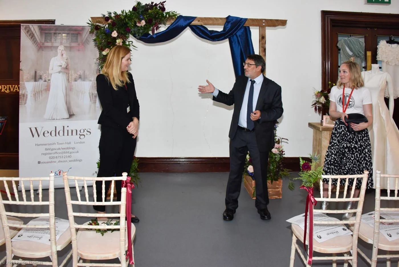 Layla at a wedding showcase beside a floral arch