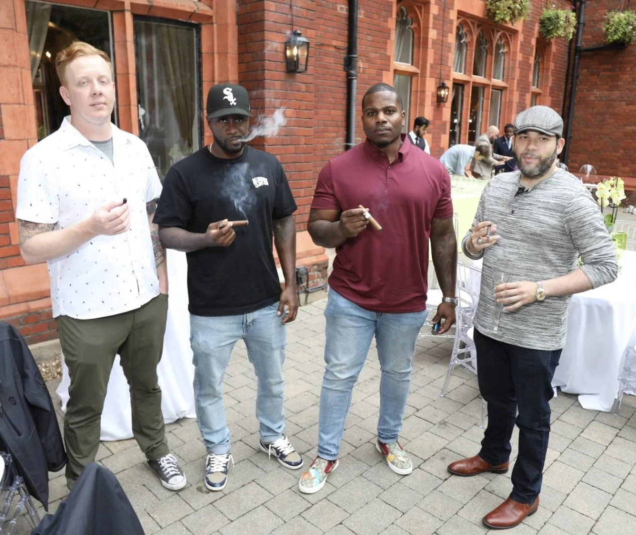 Guests enjoying cigars outside the red brick hotel