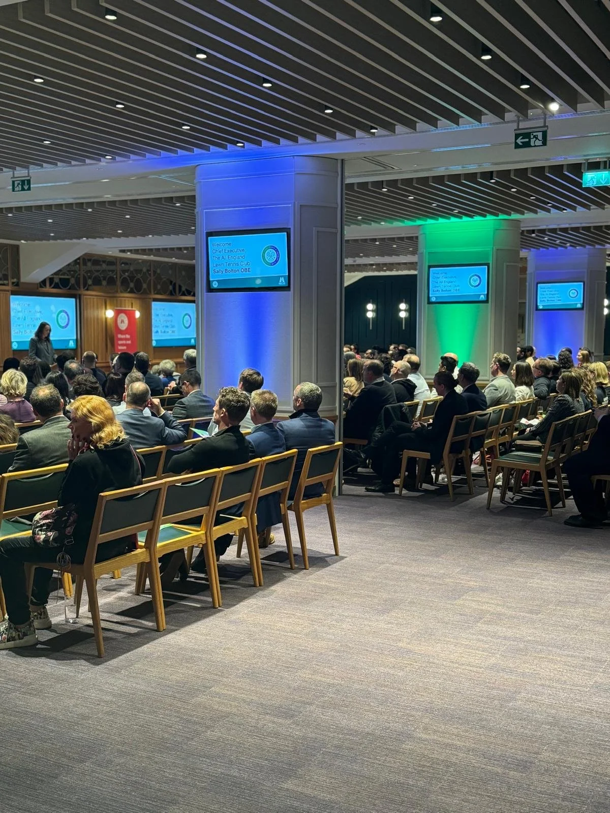 Guests seated for the welcome speech under blue and green uplighting