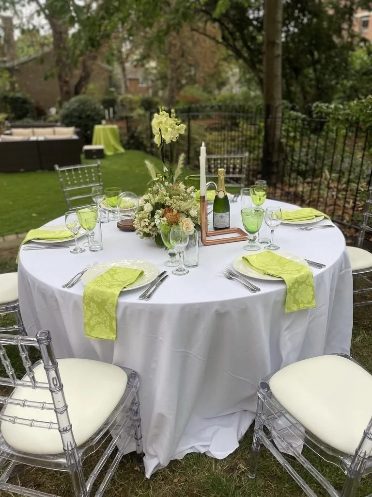 A table set with lime napkins, green glassware and a copper candle holder