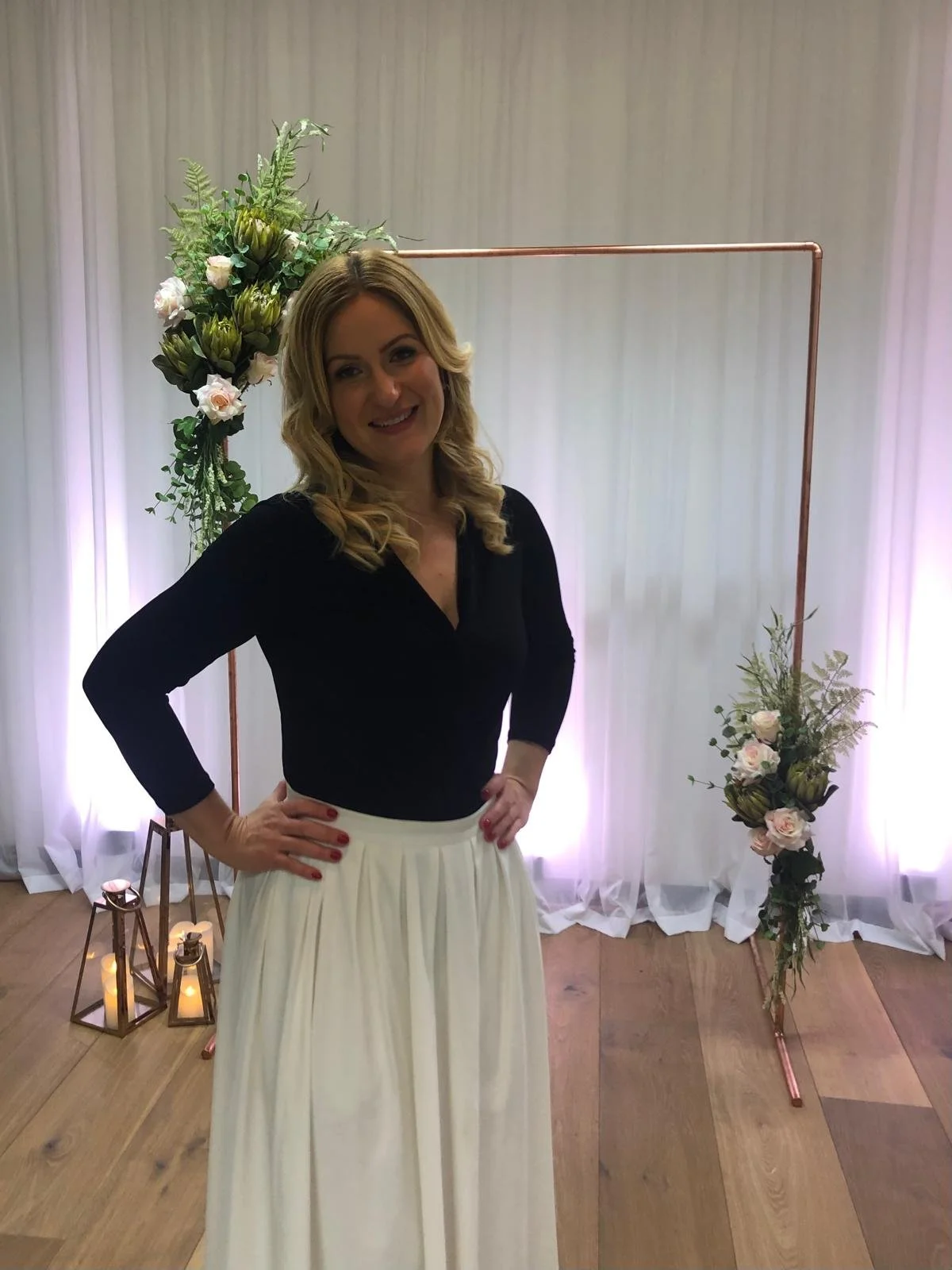 Layla in front of the copper arch she designed and dressed with roses and proteas