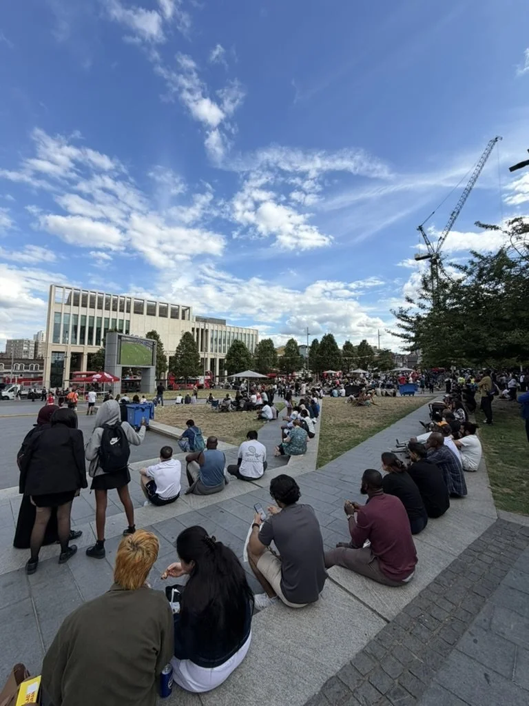 Crowds watching a big screen at a community event