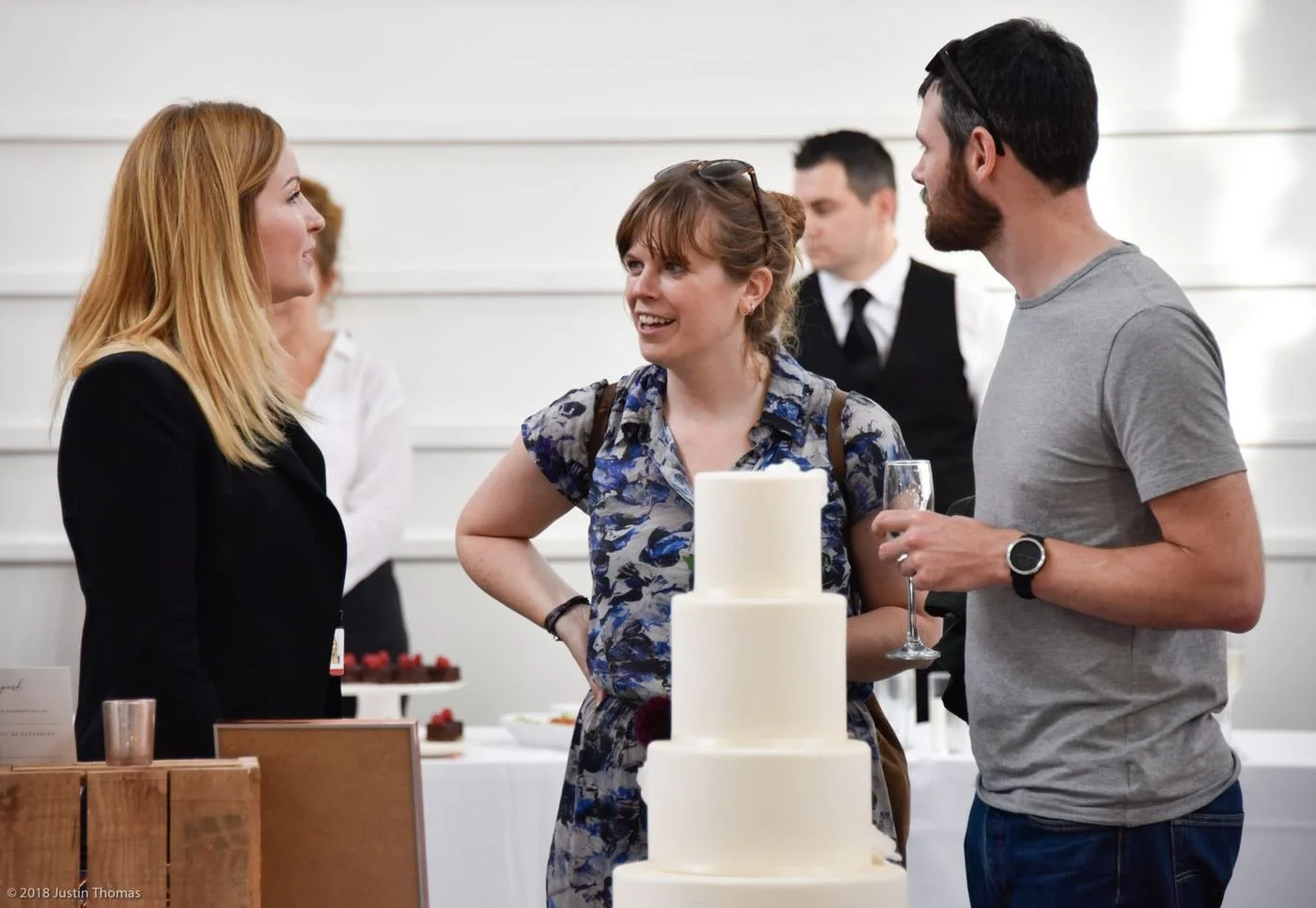 Layla chatting with a couple beside a wedding cake