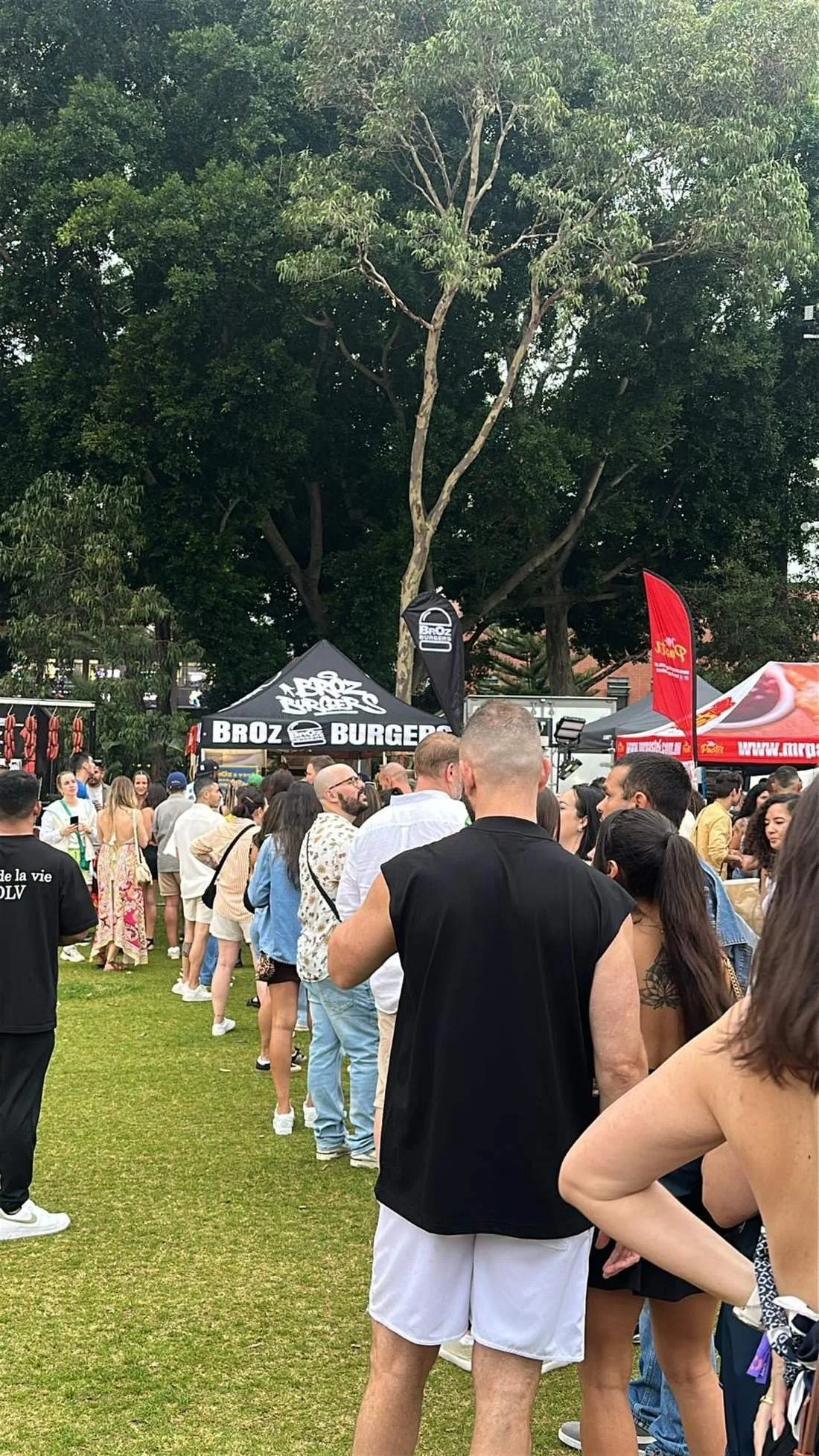 Long queue of guests at the BrOz Burgers stall during an outdoor Sydney music event