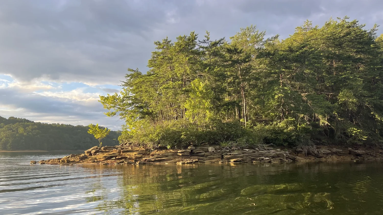 Late sunlight warming the Laurel River Lake sandstone point depicted in Evening Along Quiet Banks
