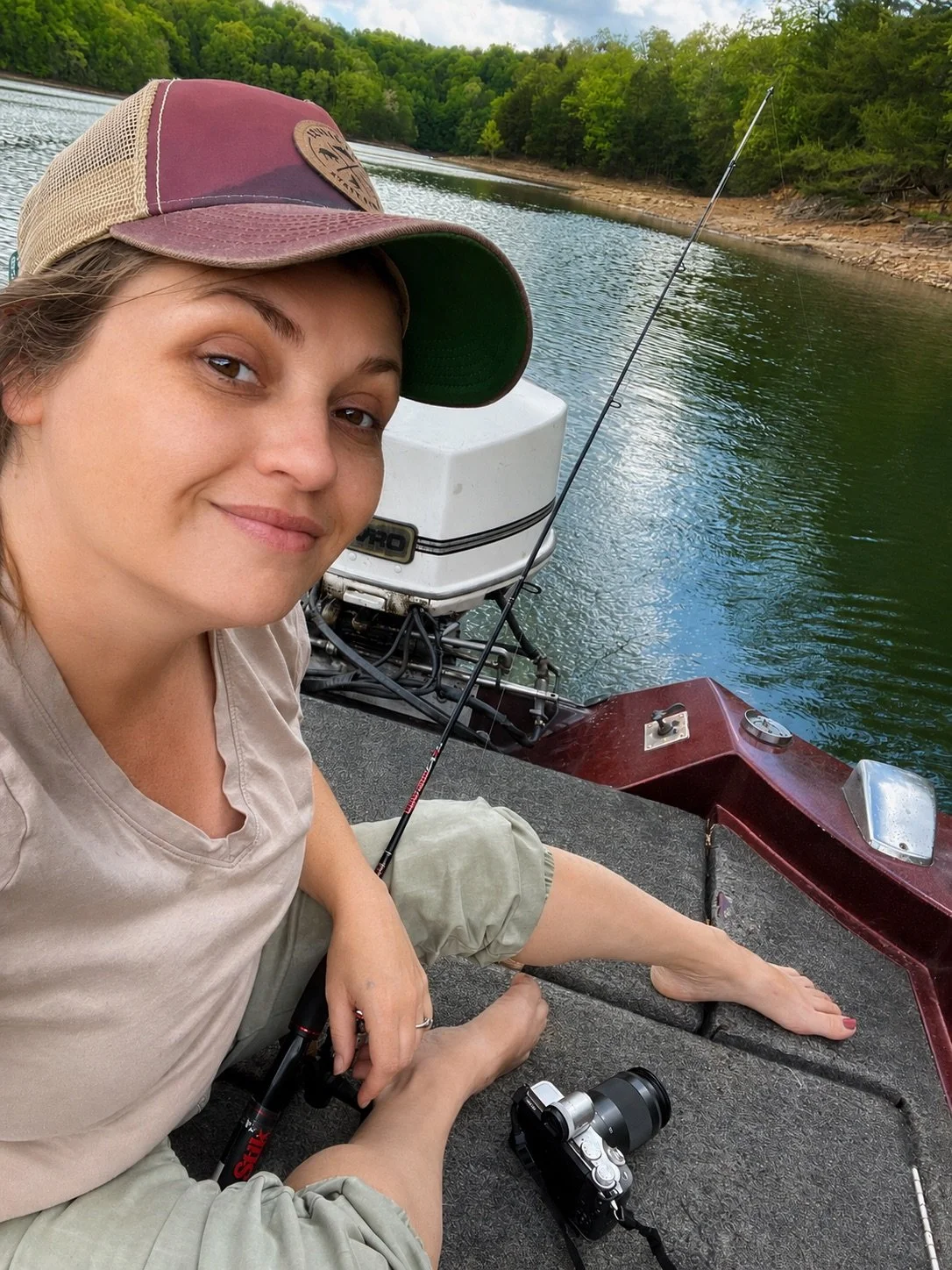 Rachel Stepek holding a camera on a boat while gathering lake reference photos