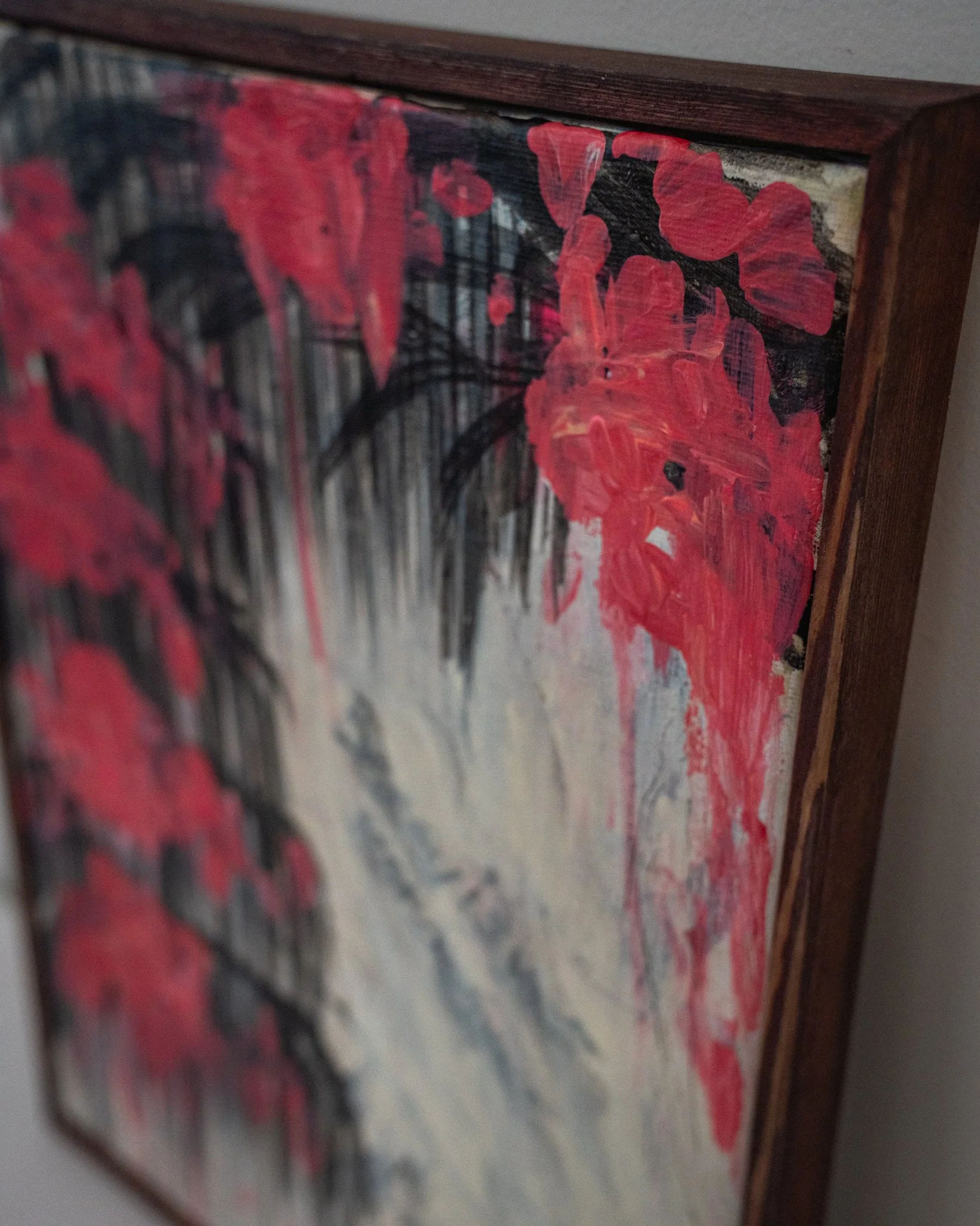 Blind Spots — top corner detail of red impasto over black brushwork and pinewood frame edge