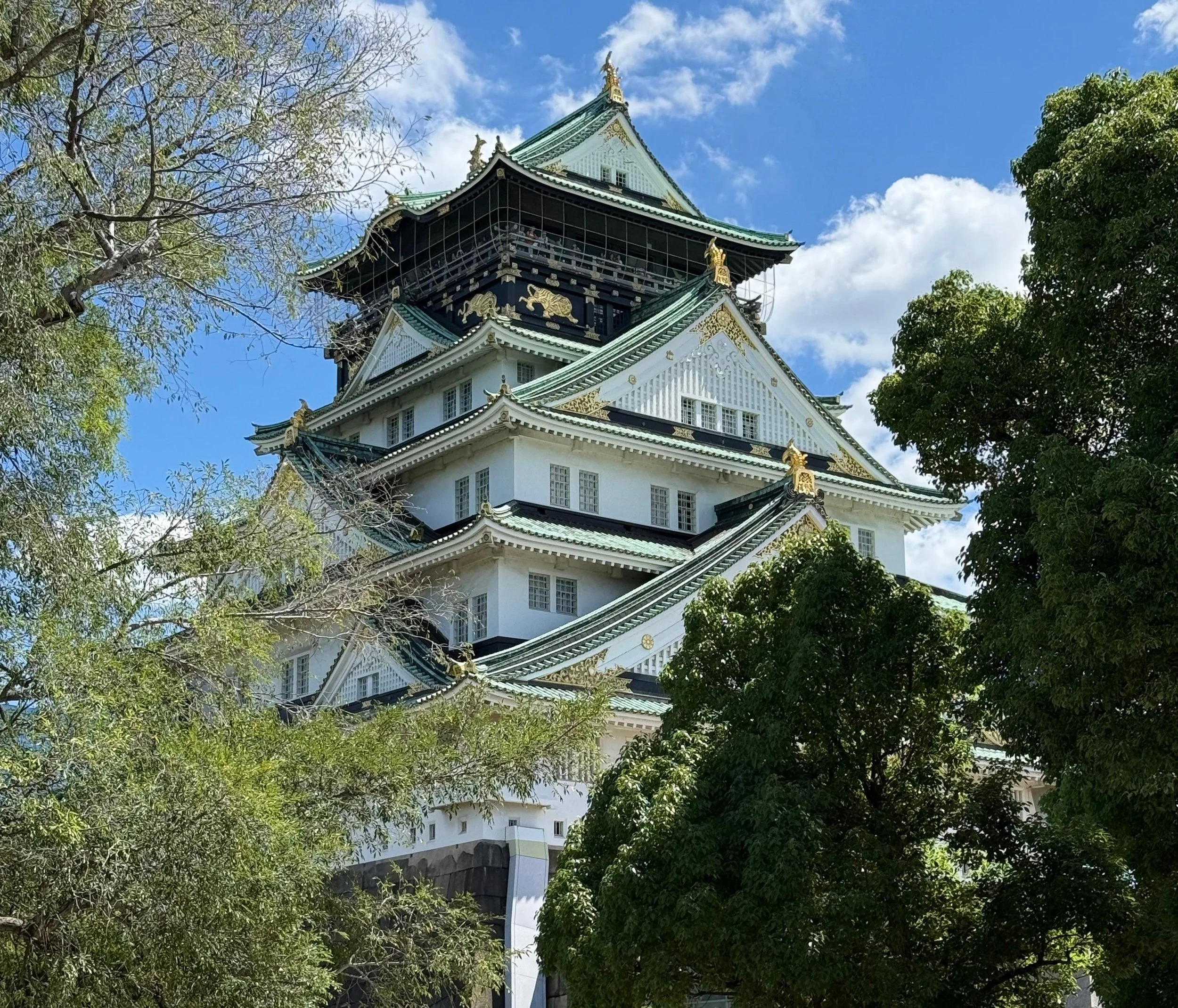 Castelo de Osaka cercado de vegetação e céu azul