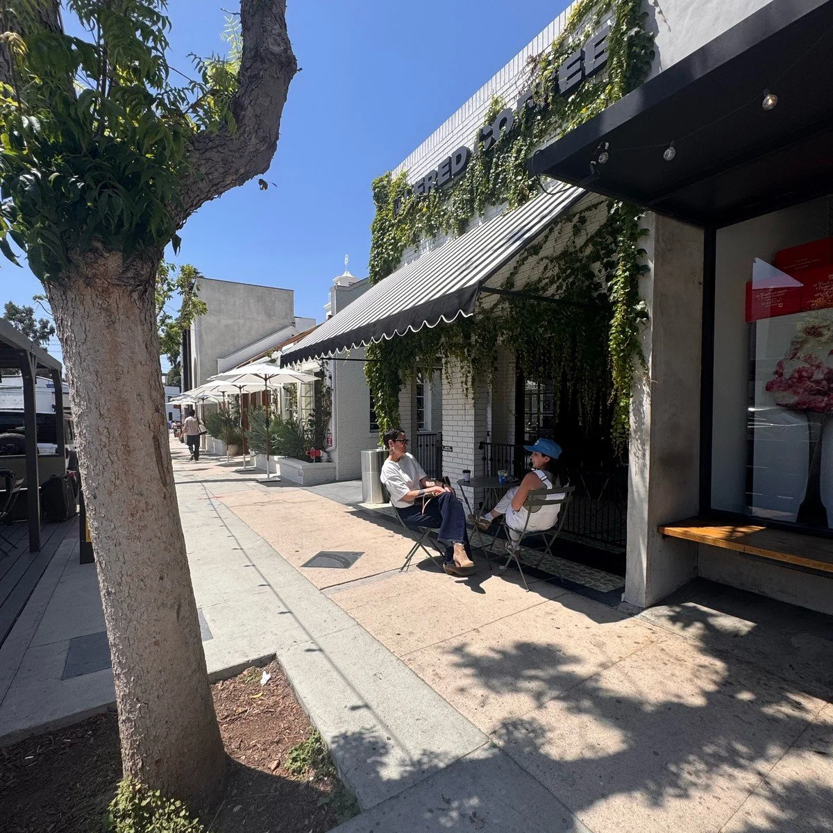 Ivy-covered coffee shop with sidewalk seating in Studio City