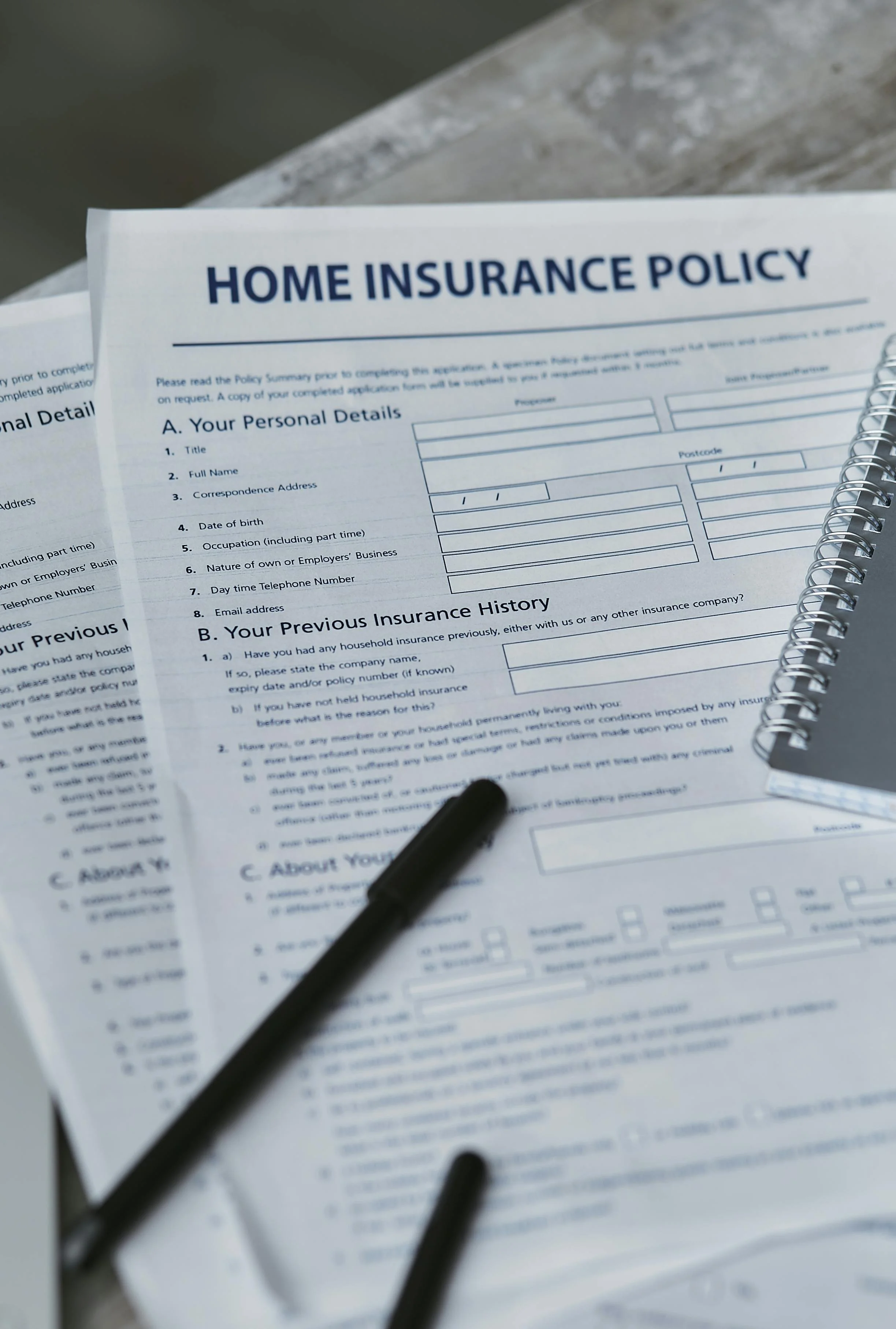 Home insurance policy paperwork with pen — illustrating the post-wildfire claim process for Western homeowners.