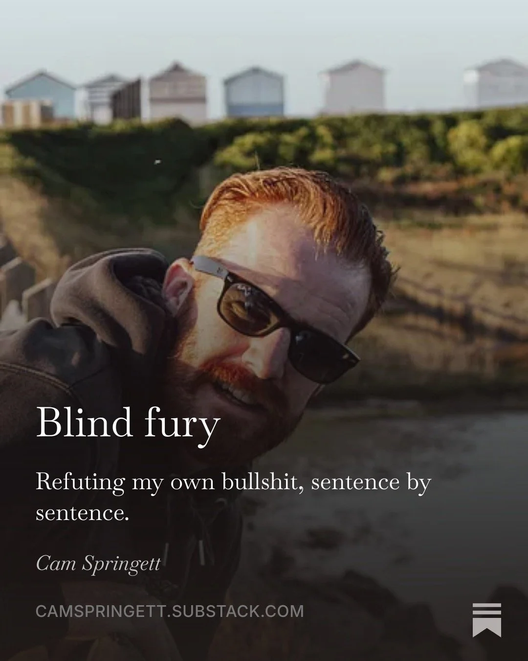 Blind fury. Refuting my own bullshit, sentence by sentence. Cam Springett in sunglasses, tilting his head towards the camera, with beach huts on the cliff behind.