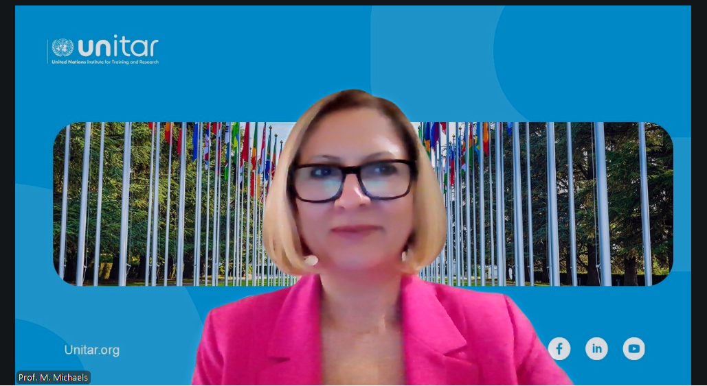 Mary Michaels in a pink blazer during an online teaching session with a UNITAR background.
