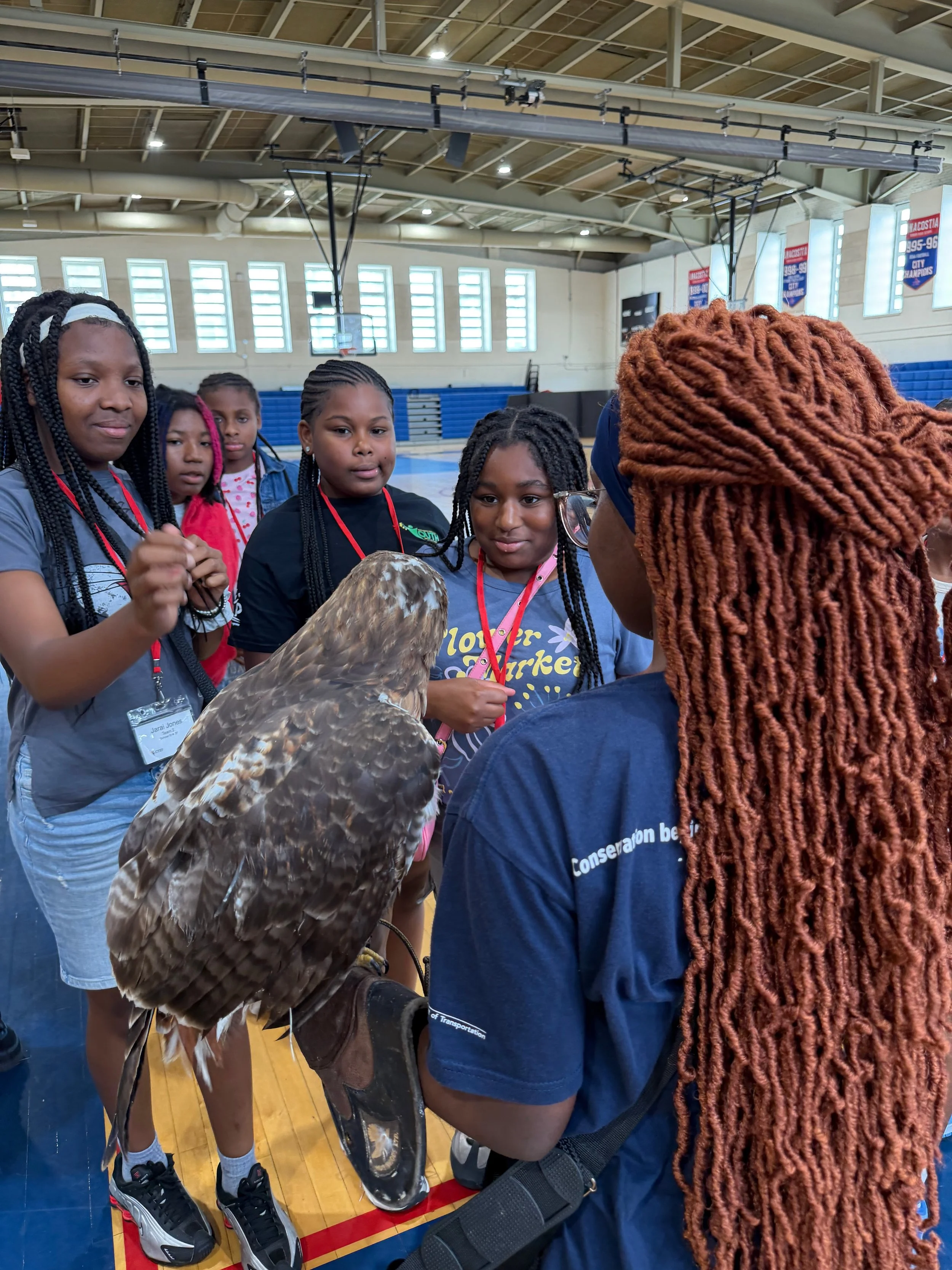 Young people gathering around a raptor educator during a 2026 wildlife learning session.