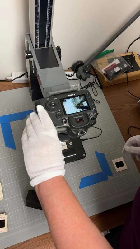 Gloved hands operating a slide-scanning rig