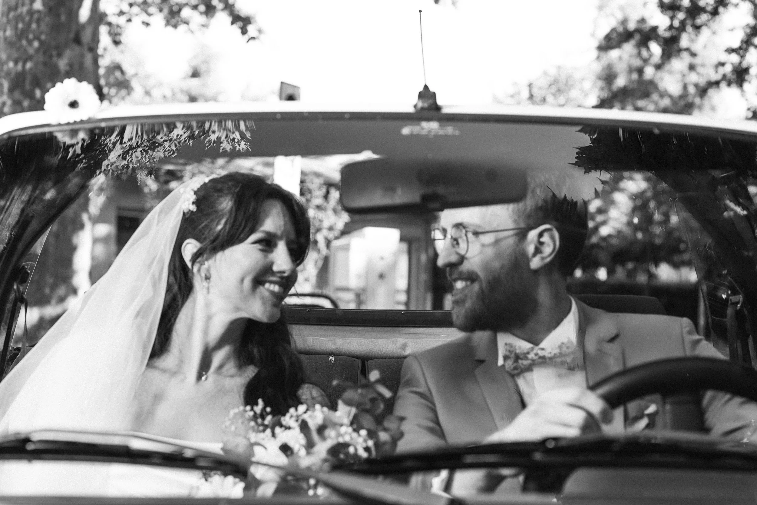 Les mariés dans une décapotable, en noir et blanc