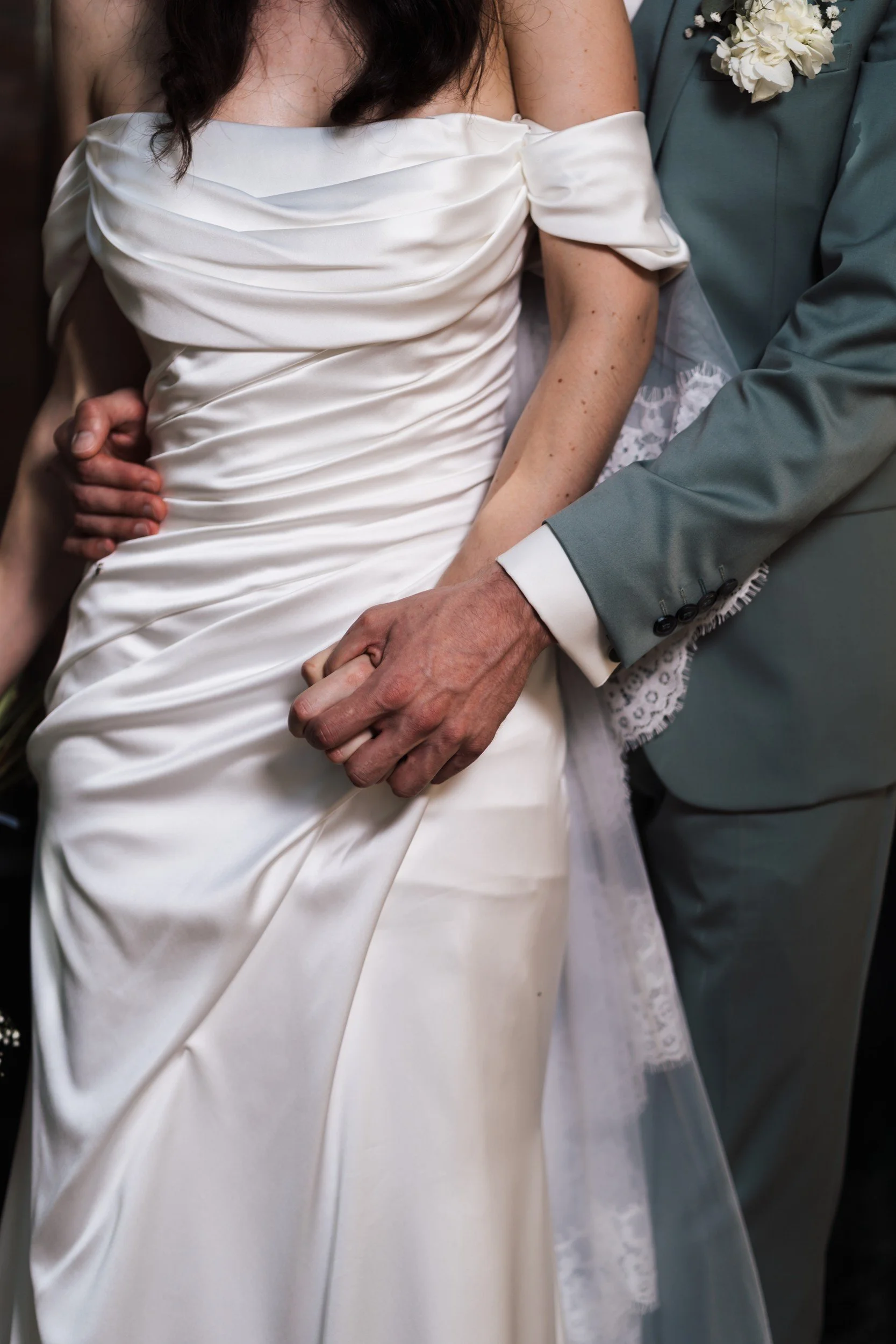 Détail de la robe et de la main de la mariée