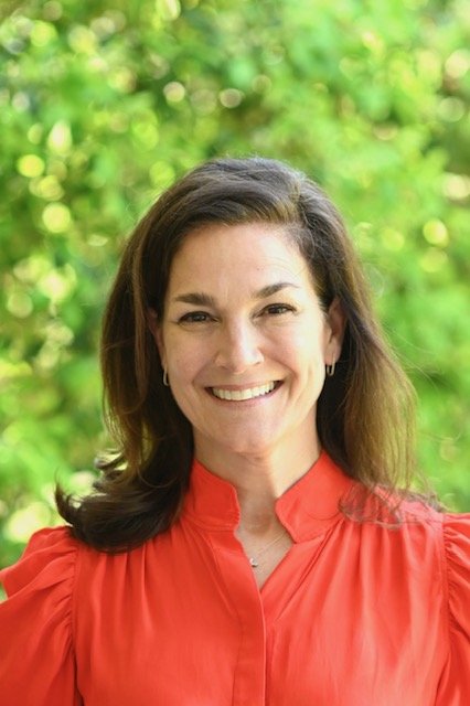 Placeholder — brunette businesswoman in office, to be replaced with Jennifer's photo