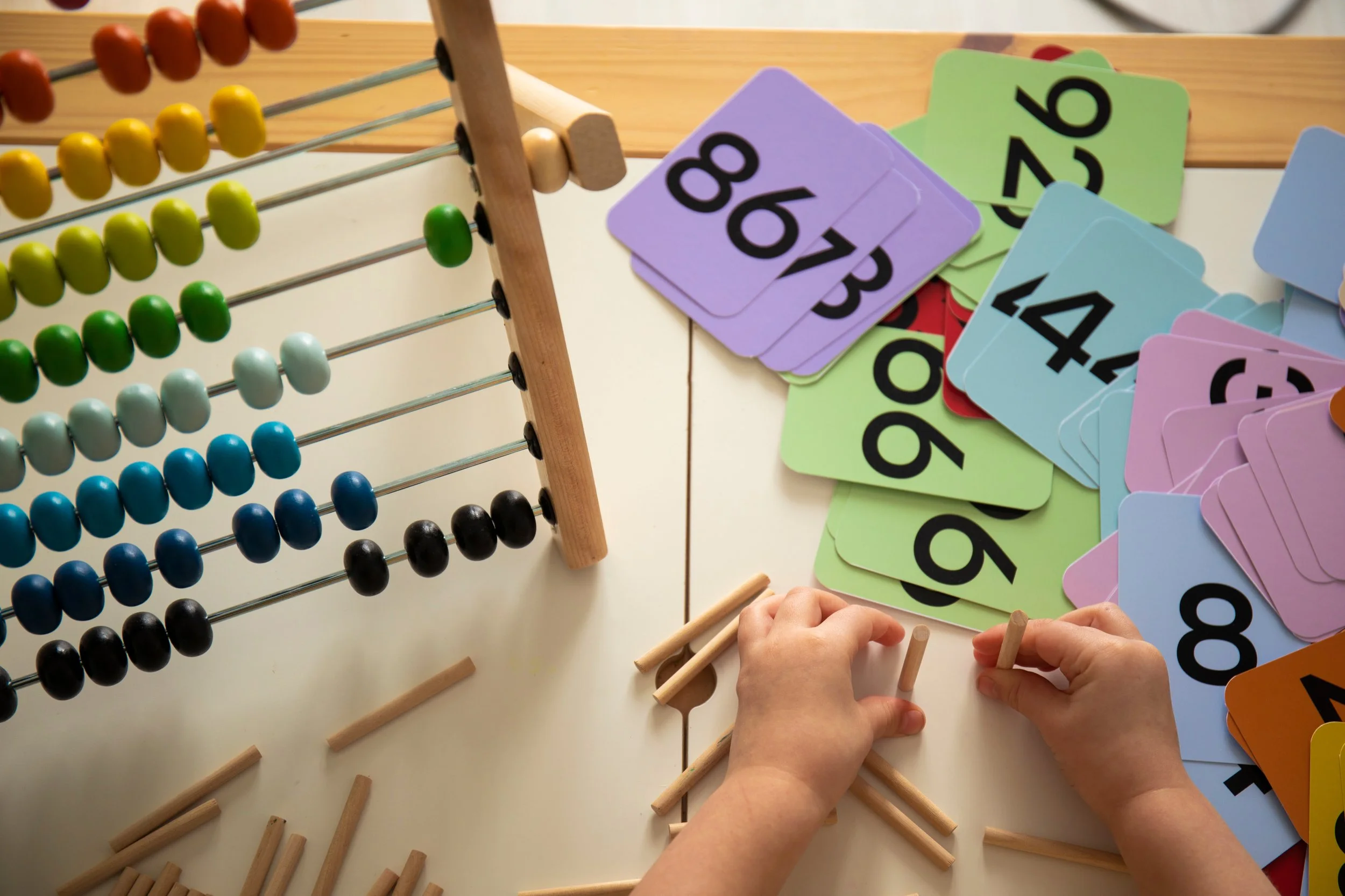 Young child using colorful counting blocks, representing mathematics