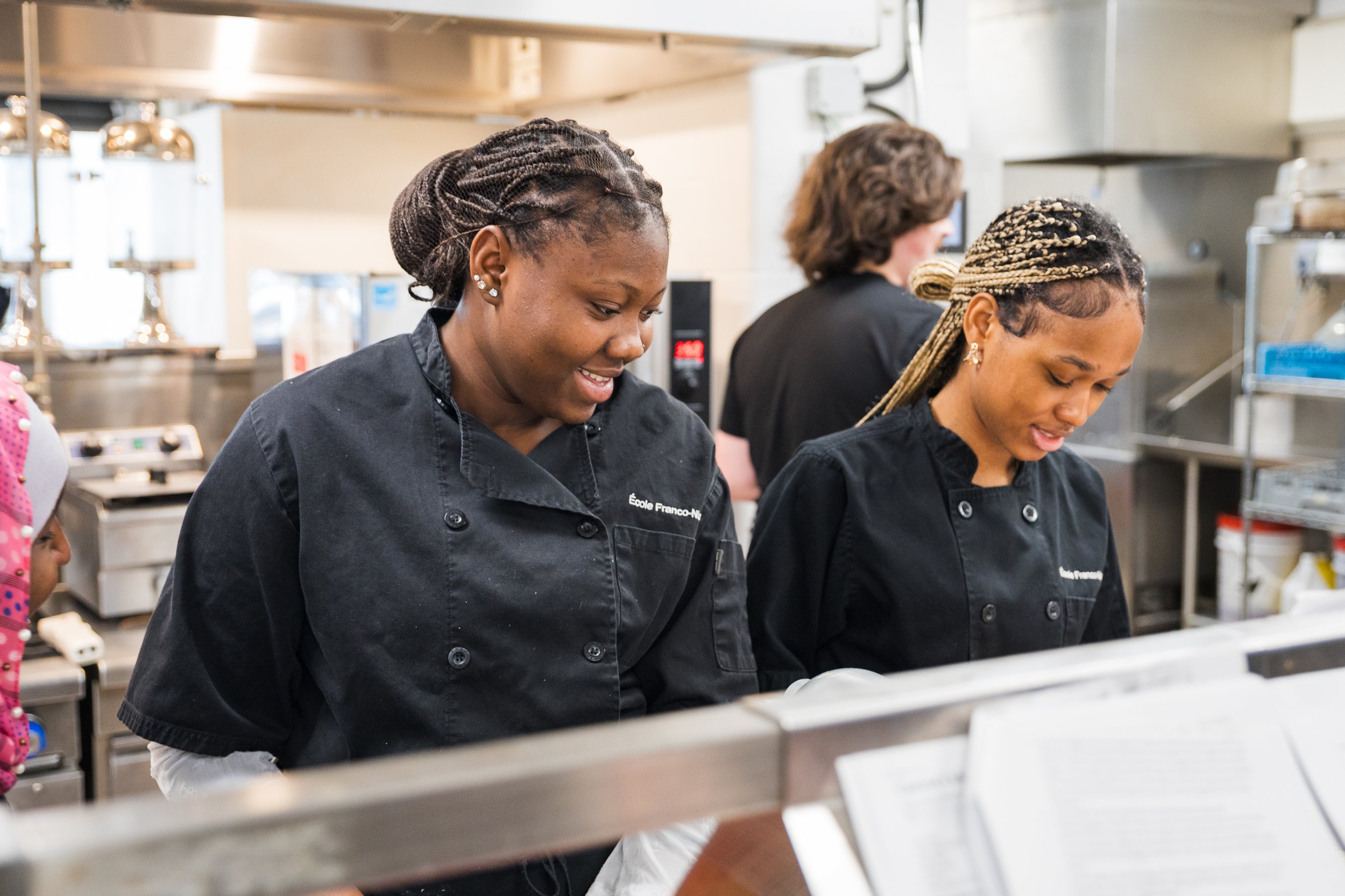 Secondary culinary students cooking in a teaching kitchen