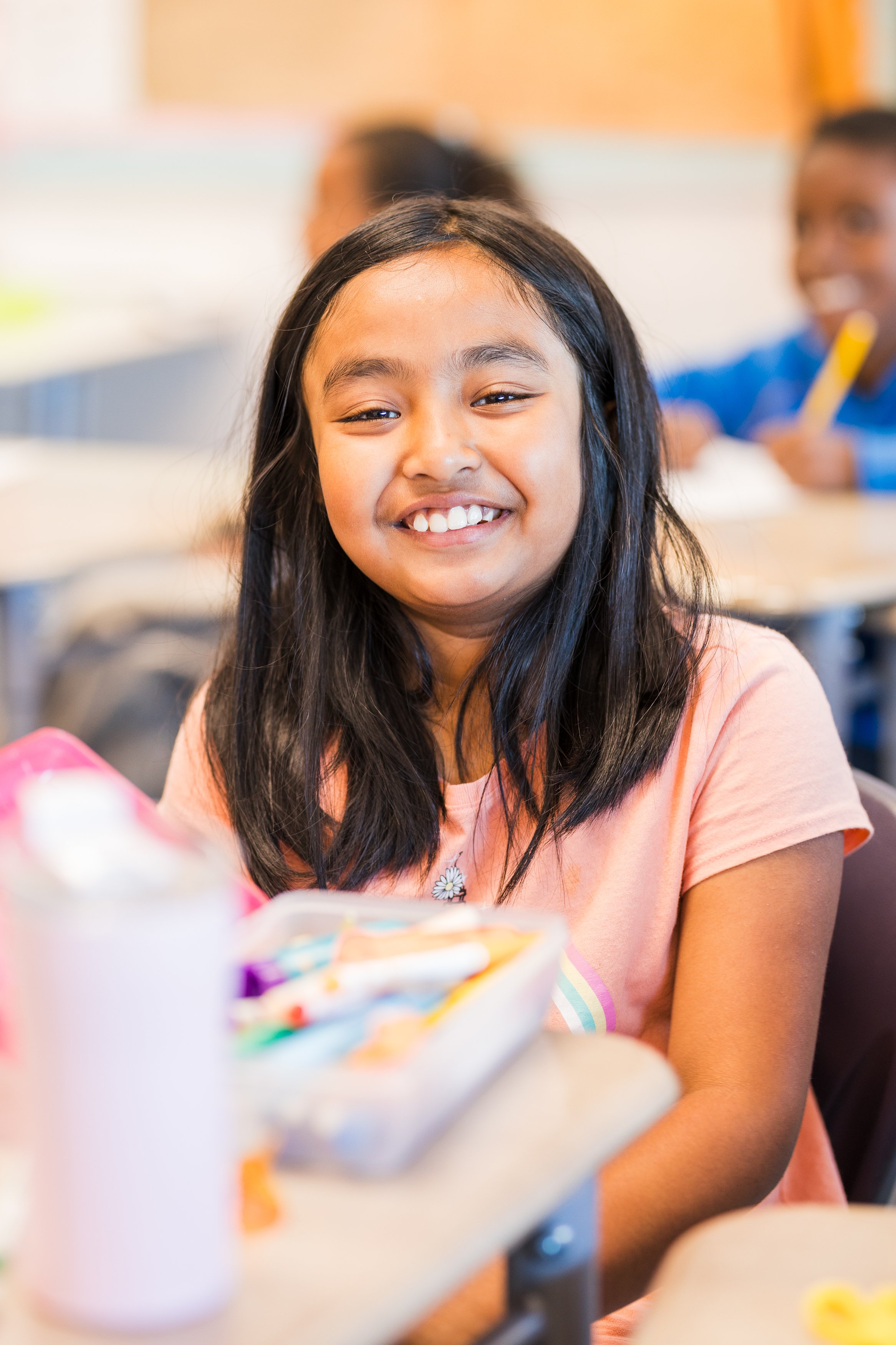 A smiling student at their desk