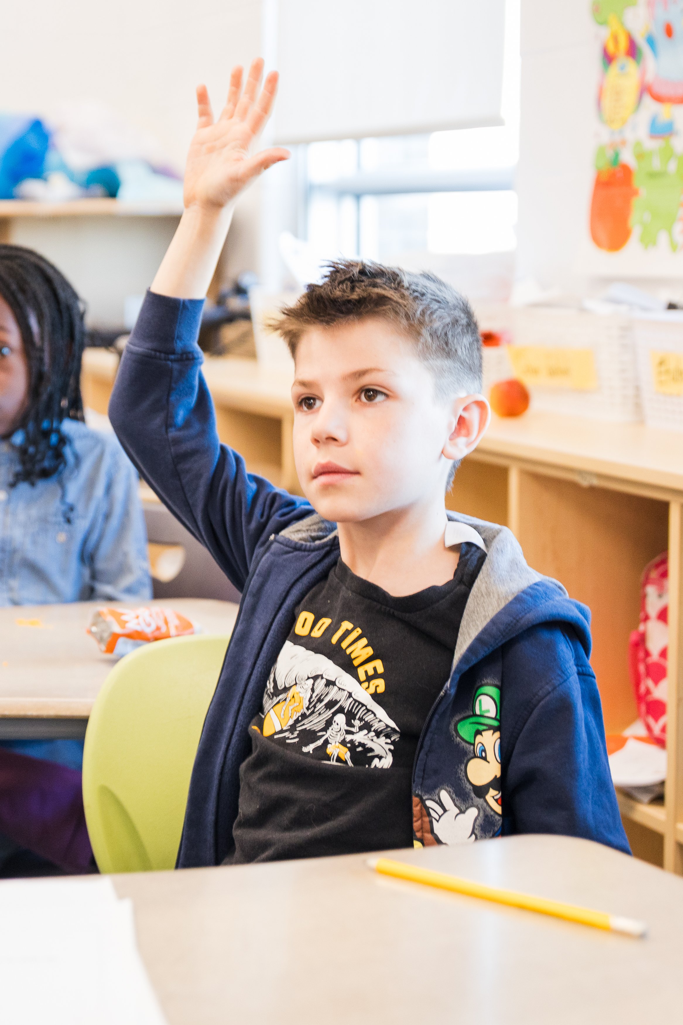A student raising their hand in class