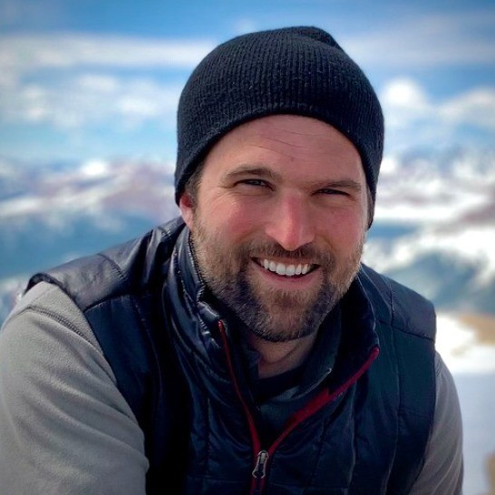 Stephen, founder of AfterProof, smiling in a black beanie with snowy mountains behind him