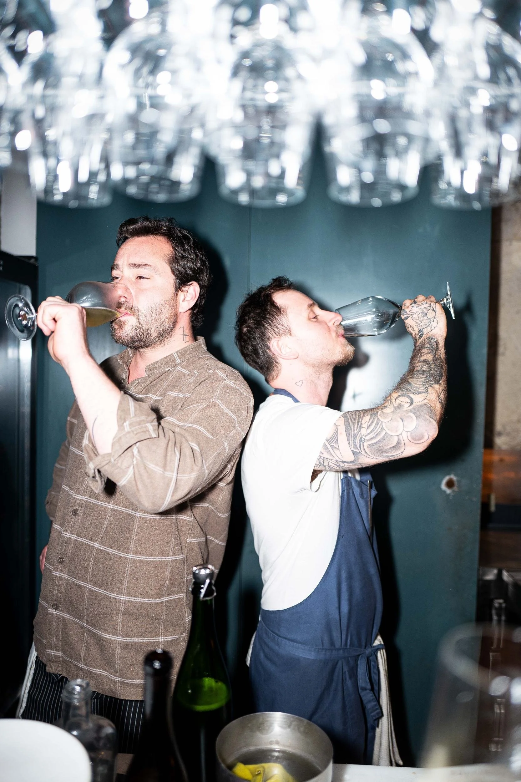 Two chefs drinking wine chandelier