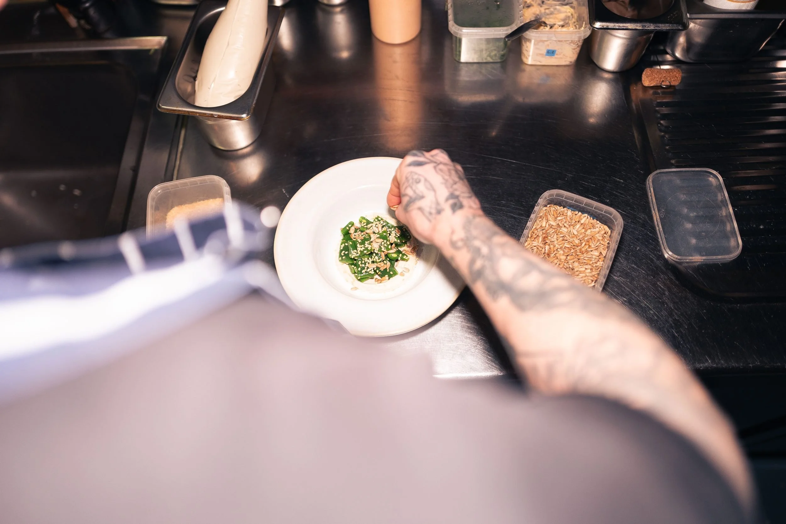 Chef plating asparagus sesame seeds