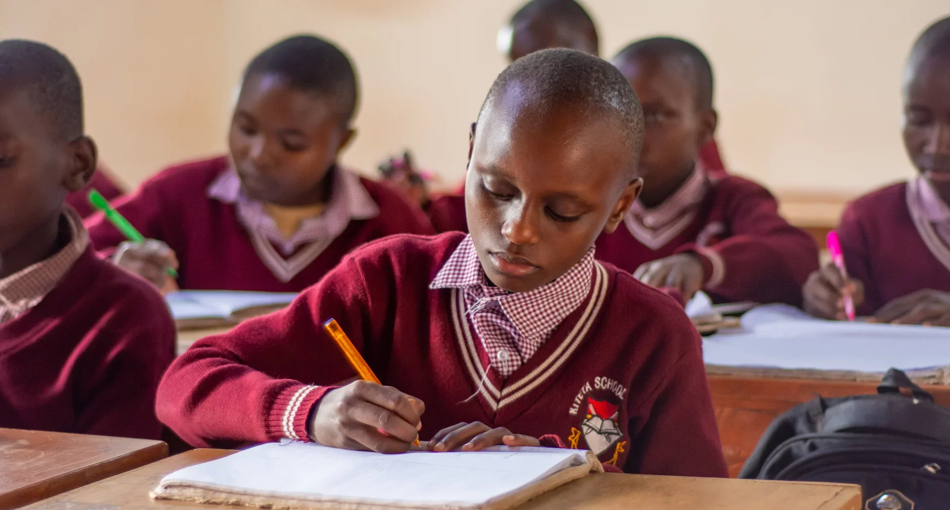 Kiteta Primary School students focused on writing in their notebooks.
