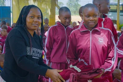 Pupil at Kiteta Primary School receiving uniforms.