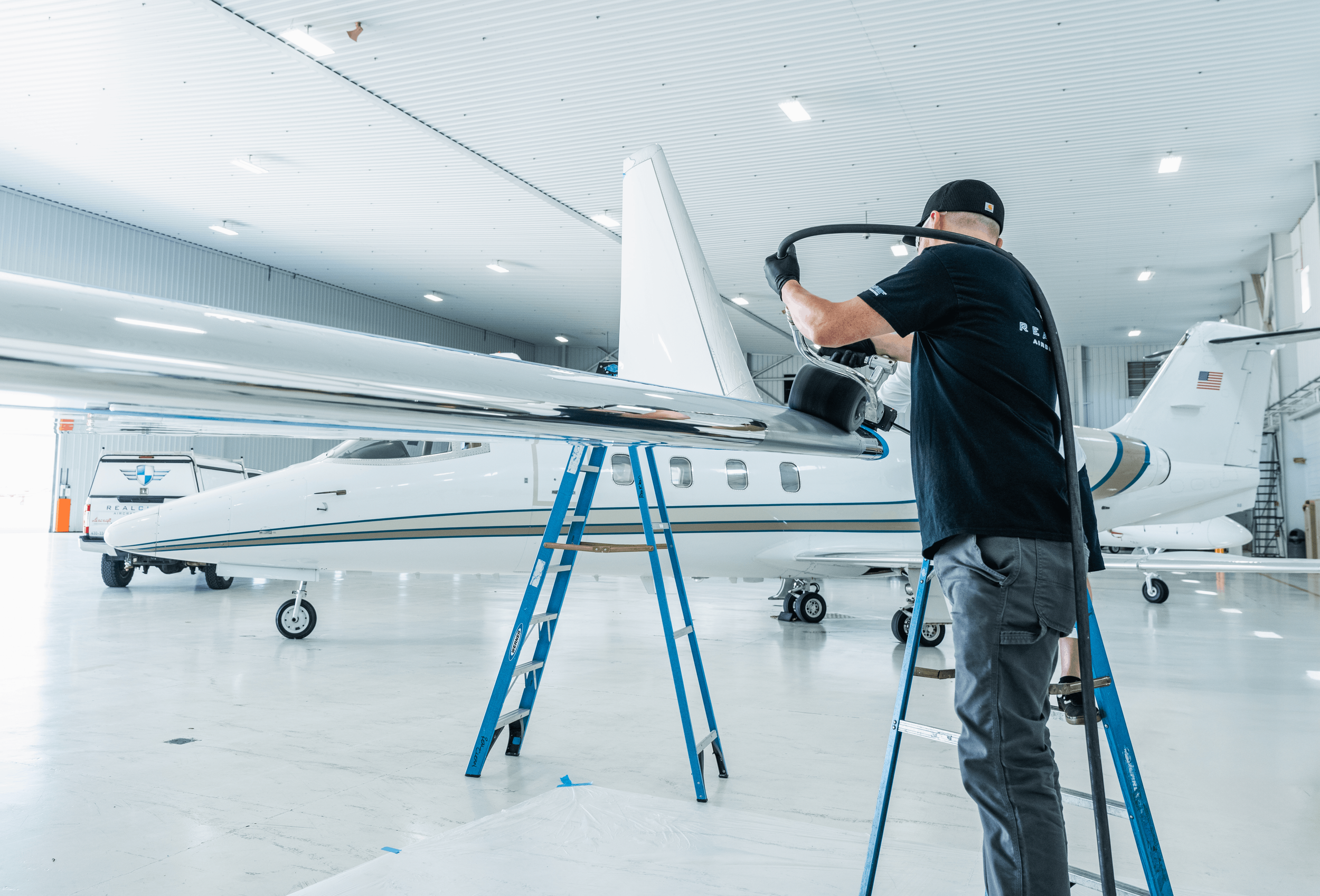Detailer working on aircraft brightwork in a Front Range hangar