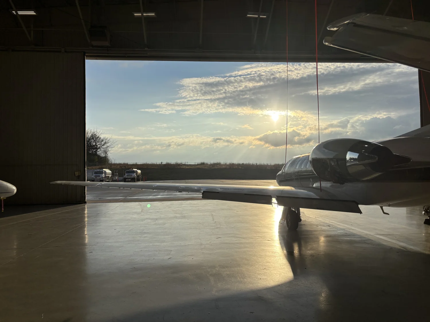 Business jet in a hangar at sunset