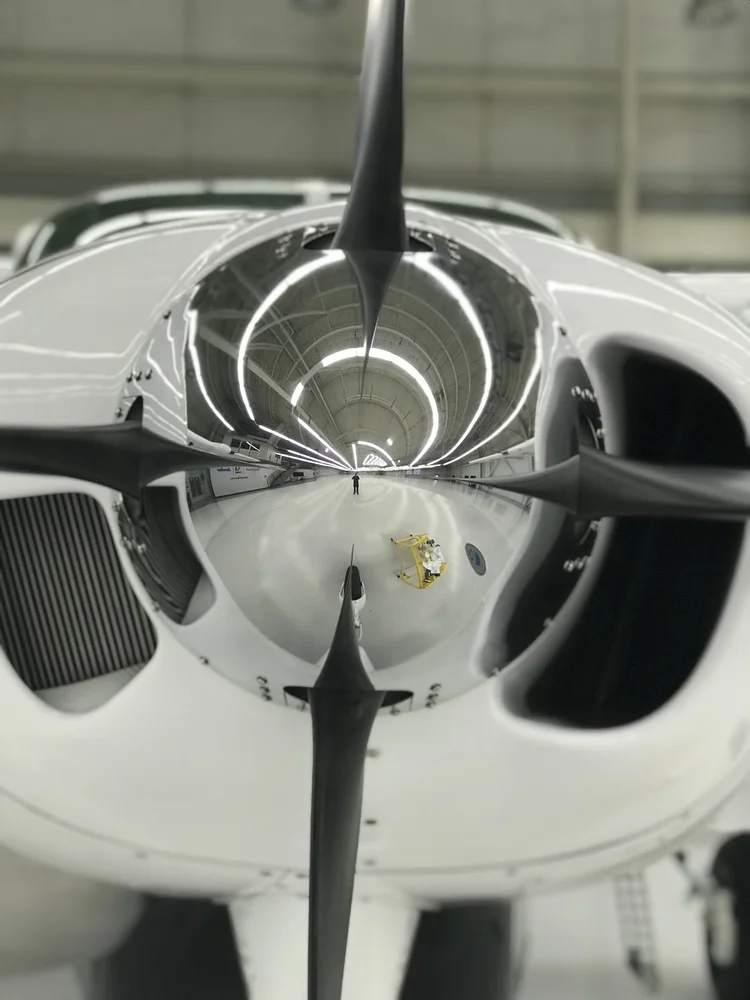 The same propeller spinner after mirror polishing, reflecting the hangar