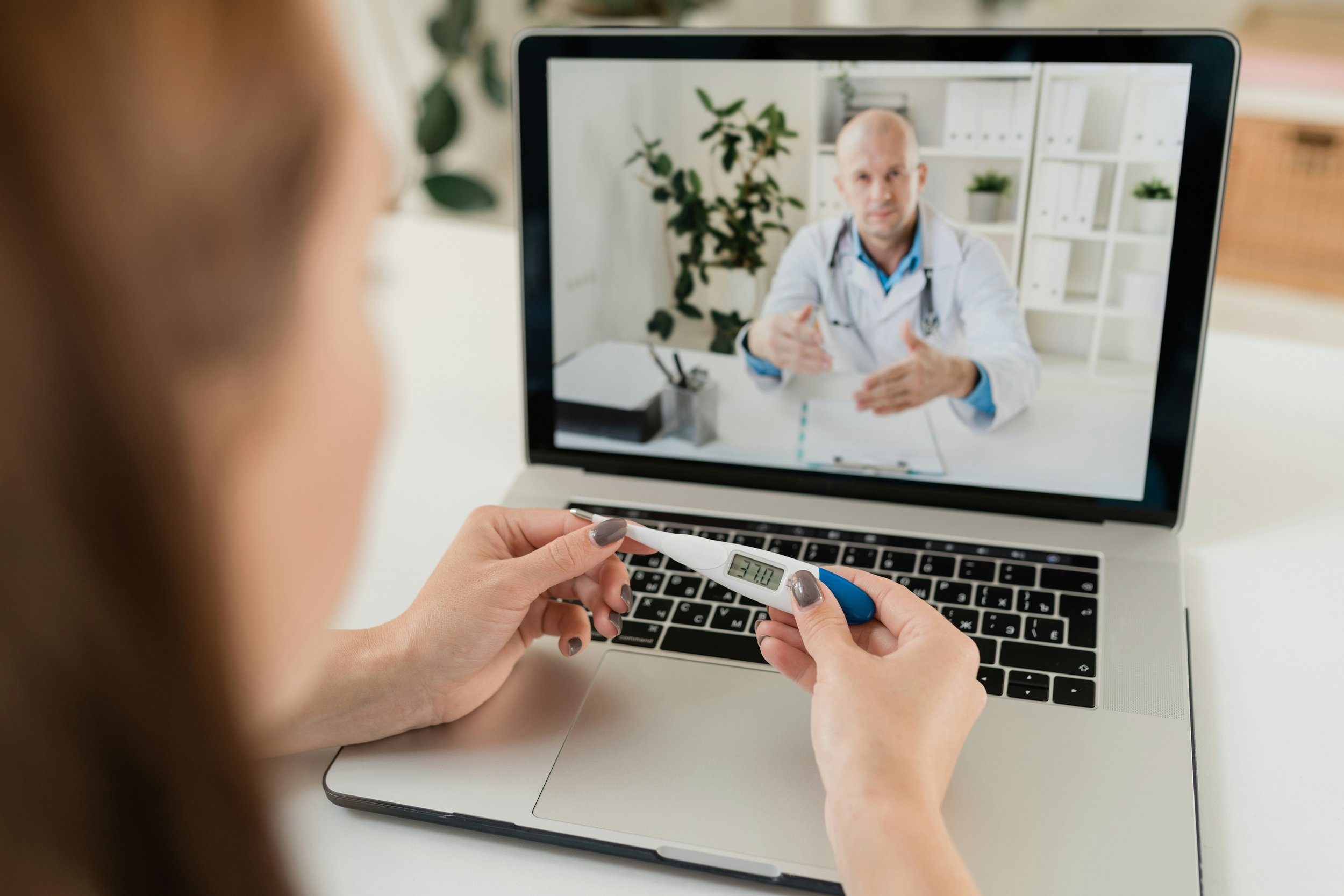 Doctor in white coat reviewing digital laptop for telehealth concierge medicine