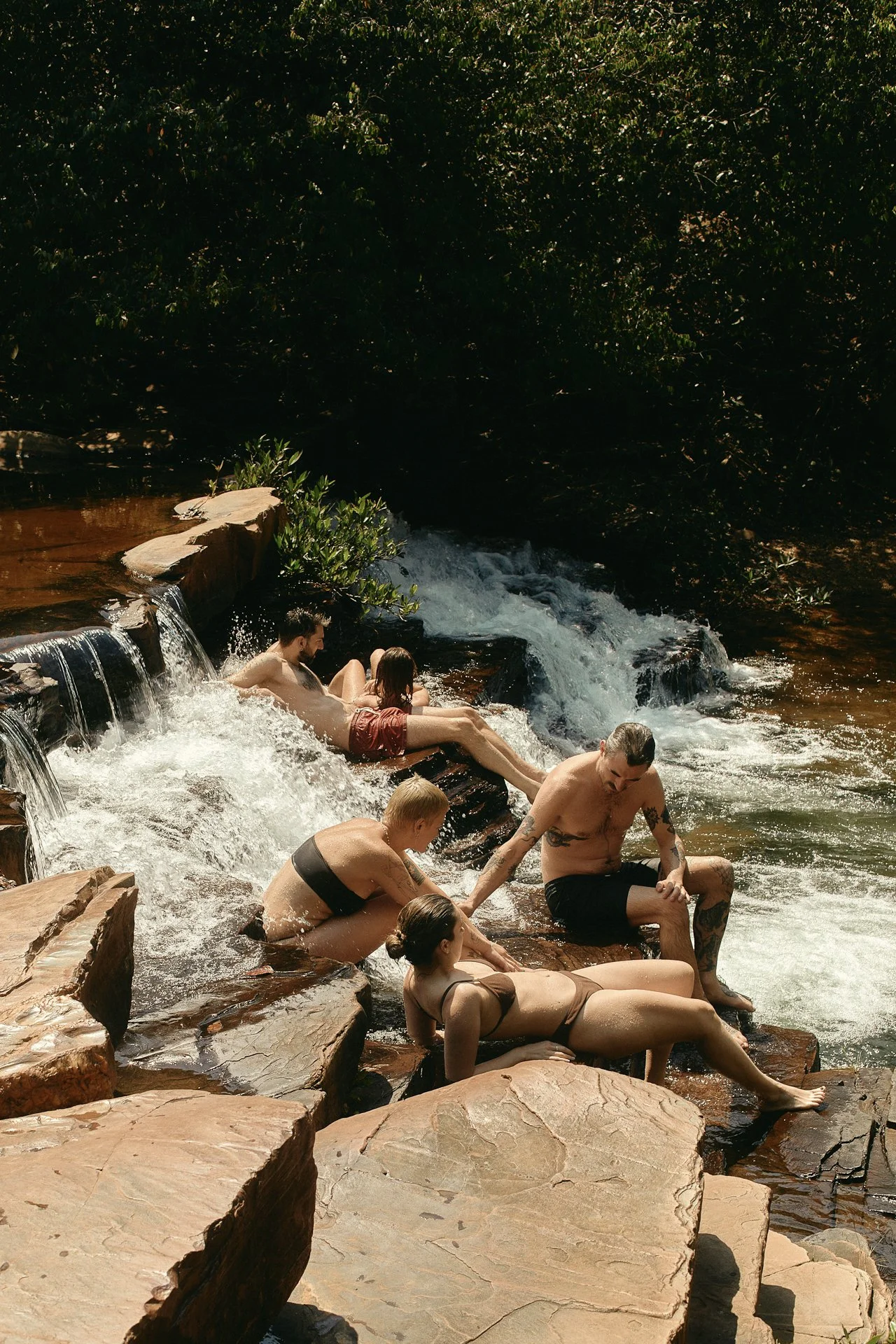 Group relaxing on natural waterfall rock pools