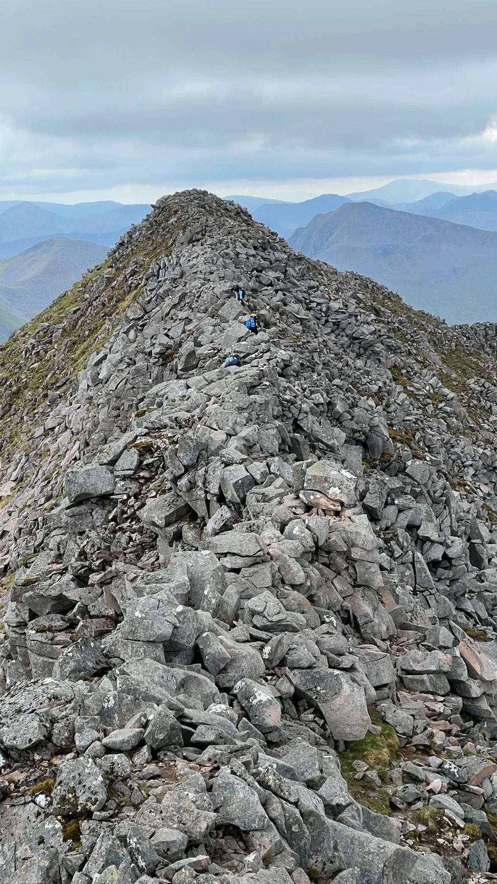 A rocky Scottish ridge offers a clear onward line towards a mountain summit.